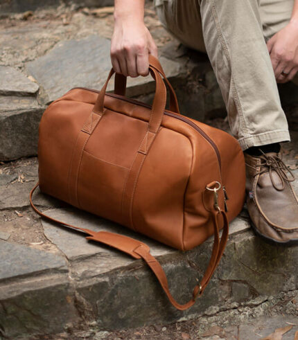 Small leather duffle bag with shoulder strap and carrying handles
