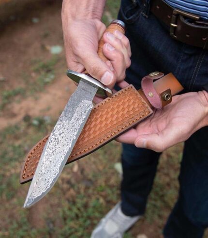 Stacked Leather Damasucs Knife held in hand lifestyle photo with sheath